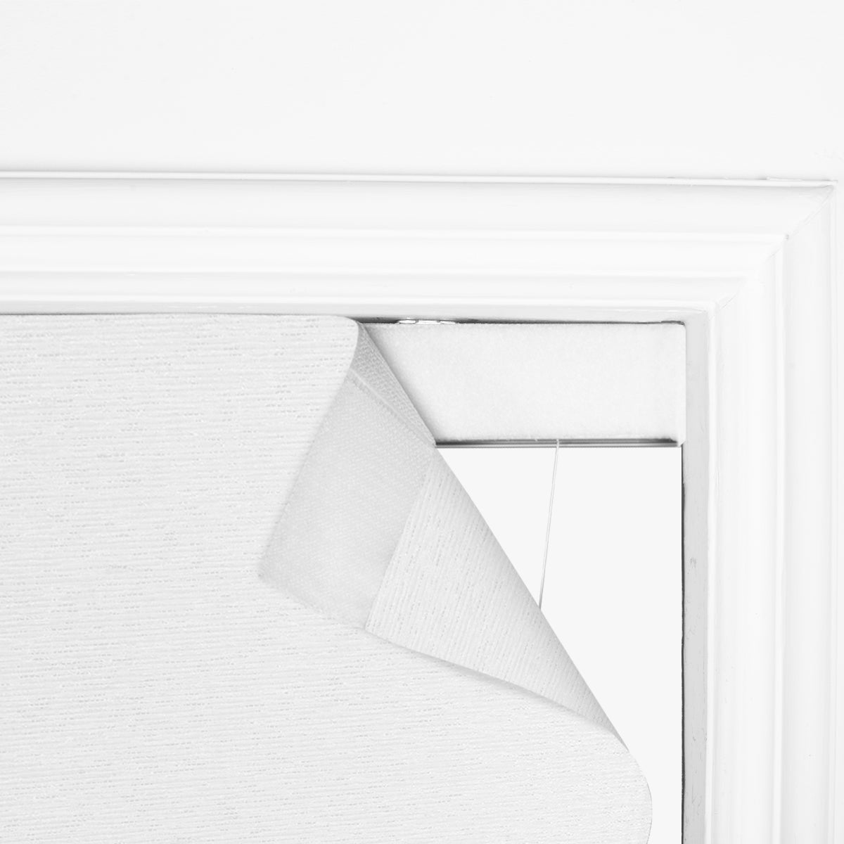 Close-up of Berissa Custom Flat Fold Roman Shade Cordless partially rolled up on a window.