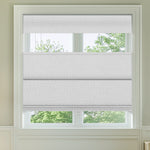 Berissa Blackout Elegant Top Down Bottom Up Roman Shades in a light gray fabric adjusting natural light in a window.