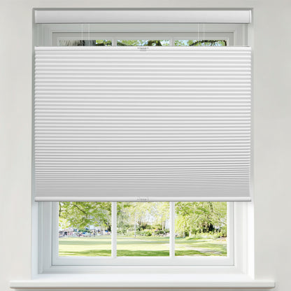 Berissa 1.5 Inch Heat Insulated Top Down Bottom Up Cellular Blinds in a window with a view of a garden.