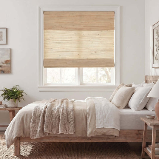 Berissa Natural Soft Glow Woven Bamboo Roman Shade in a cozy bedroom setting.