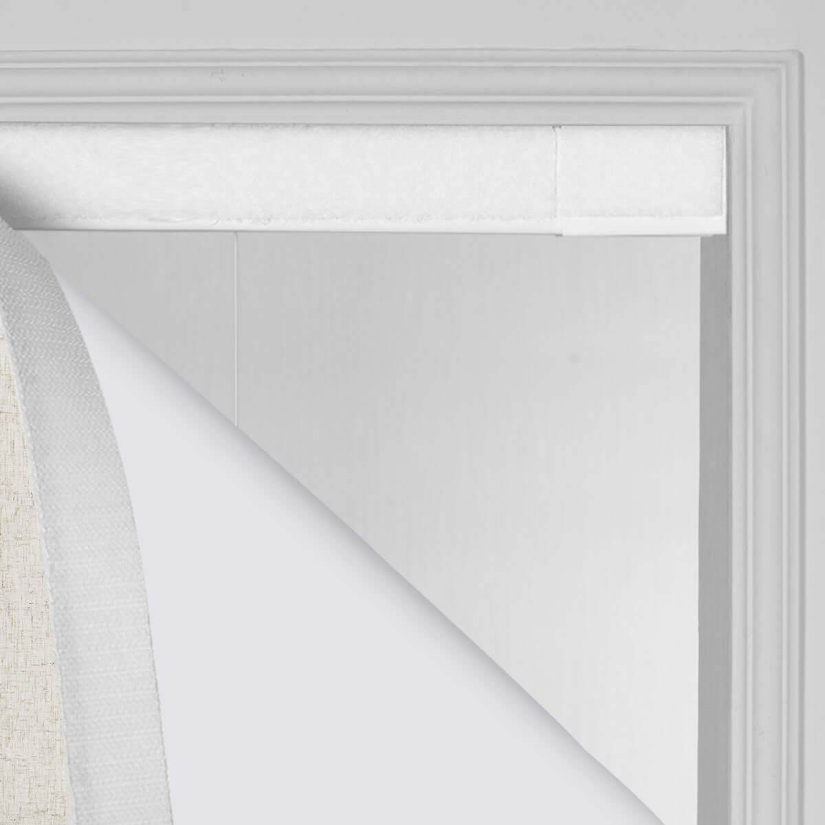 Berissa Obscura & Lumé Linen No Drill Custom Design Roman Shades installation detail showing the fabric and the window frame.